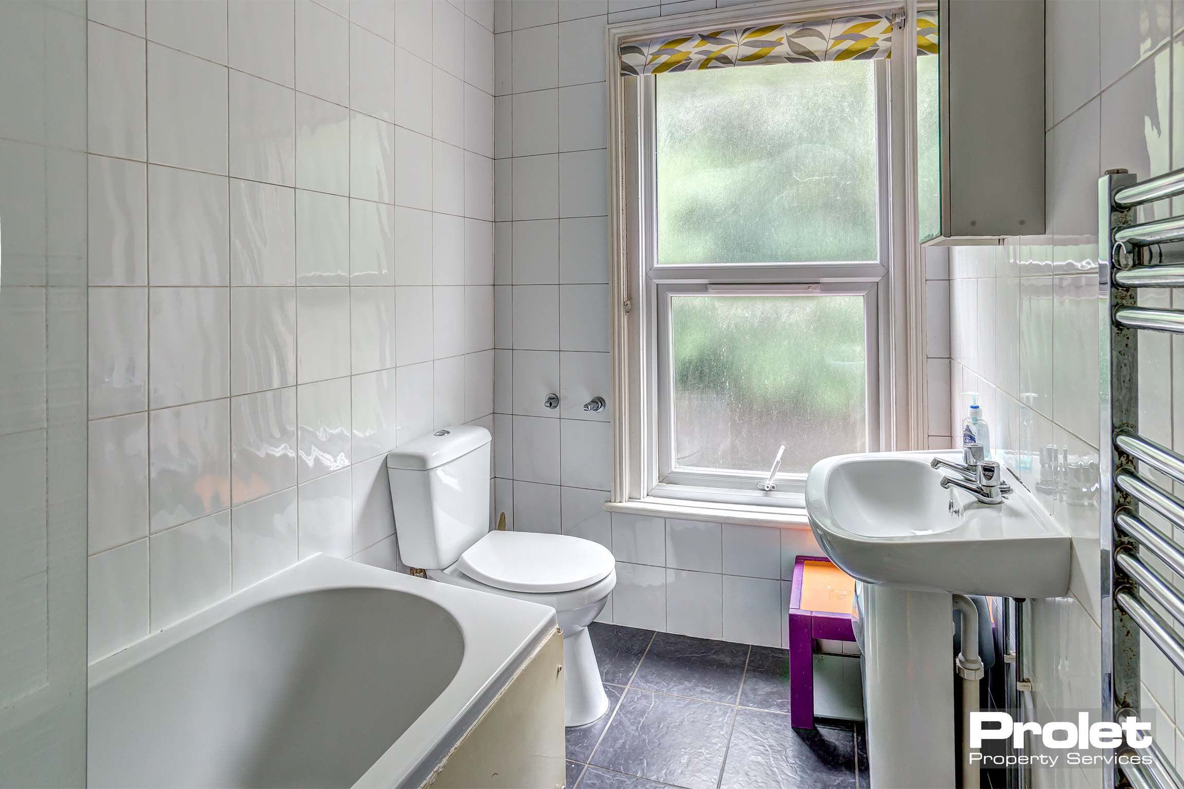 Bathroom with shower over bath, sink, toilet