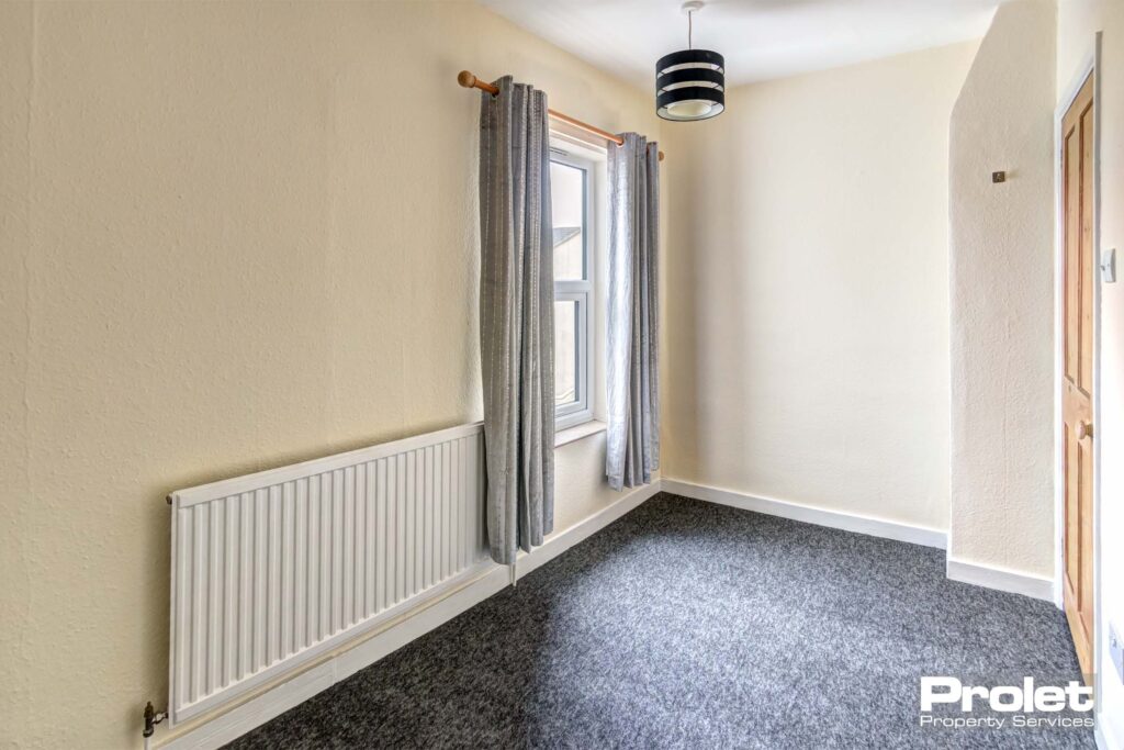 Smaller double room with grey carpets and cream walls