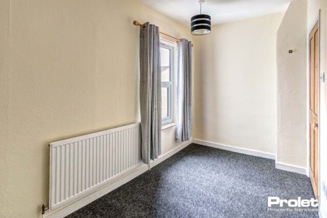 Smaller double room with grey carpets and cream walls