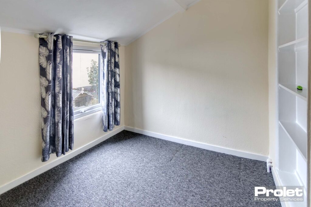 Smaller double room with grey carpets and cream walls