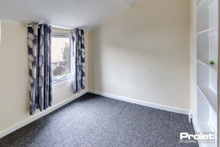 Smaller double room with grey carpets and cream walls