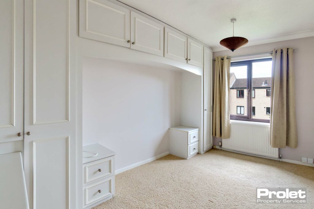 Cream carpet, off white walls with built in over bed wardrobes and bedside