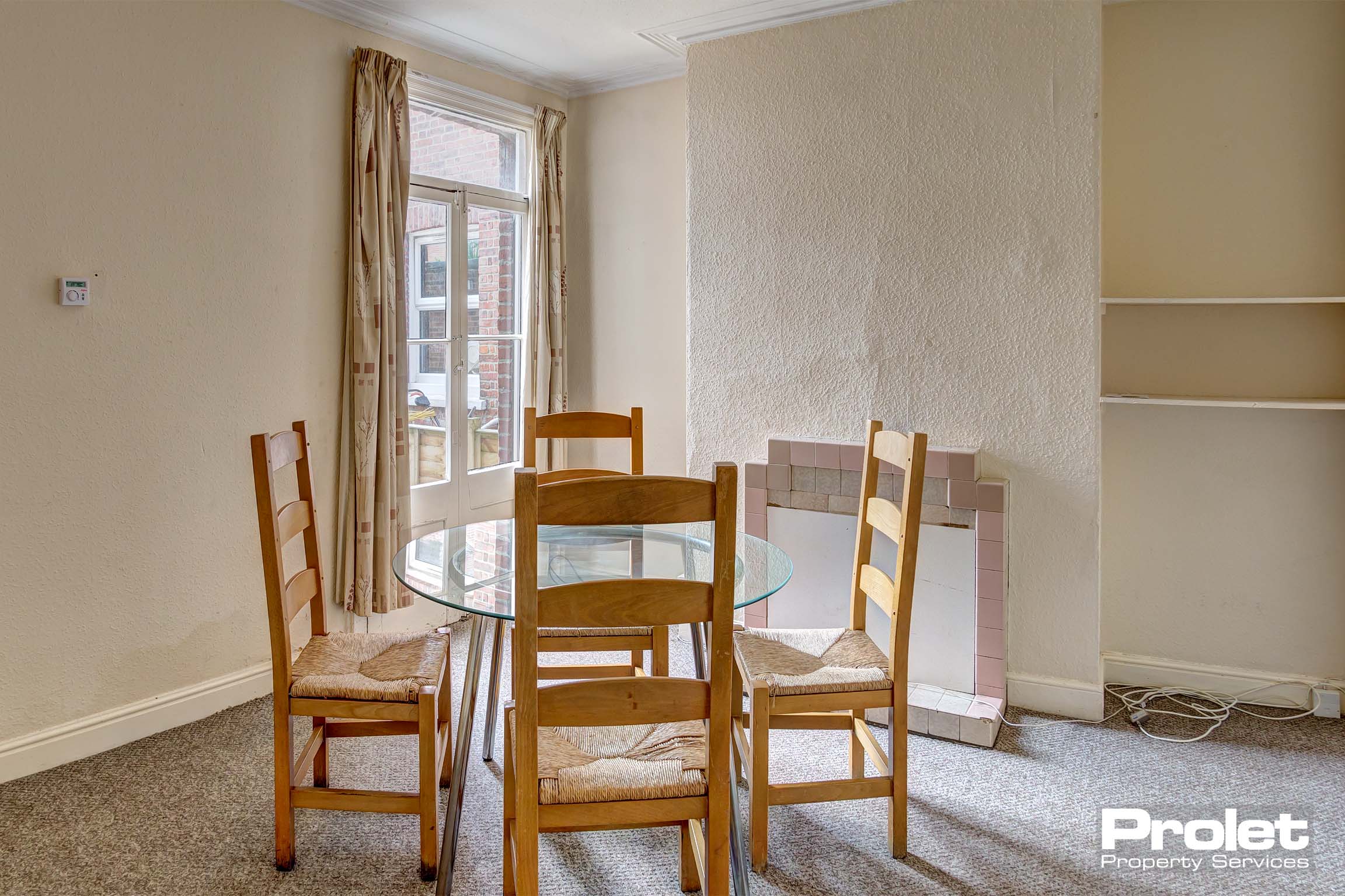Dining room with glass table and wooden chairs