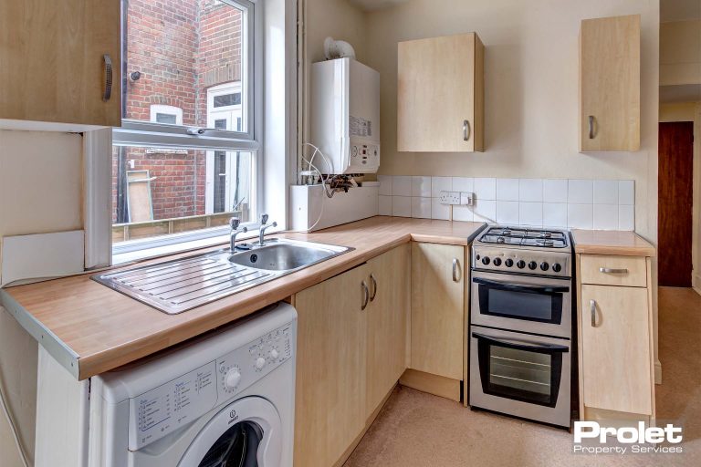 Kitchen with wood effect cabinets, and worktop, with large appliances