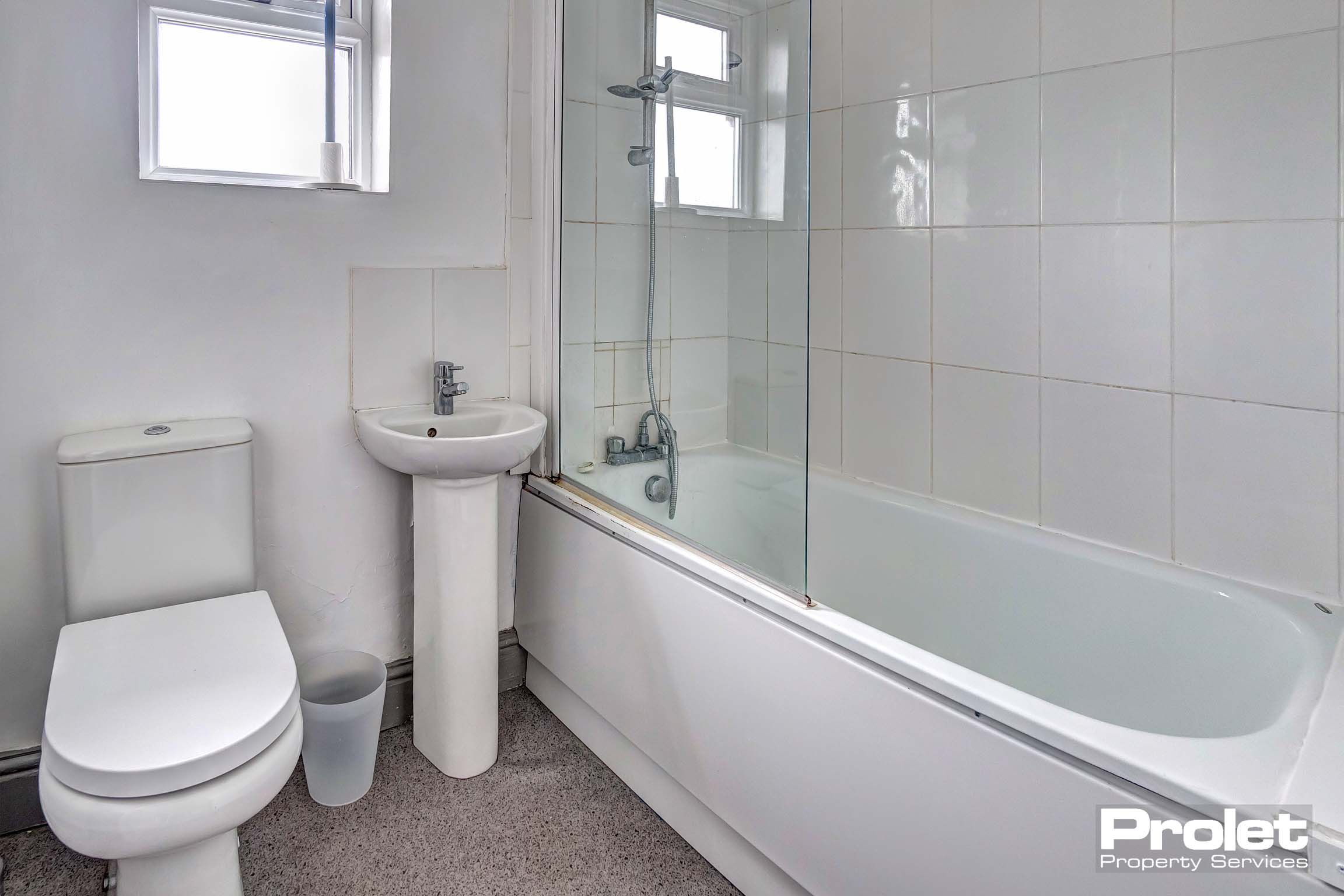 White bathroom with white bath tub, sink and toilet