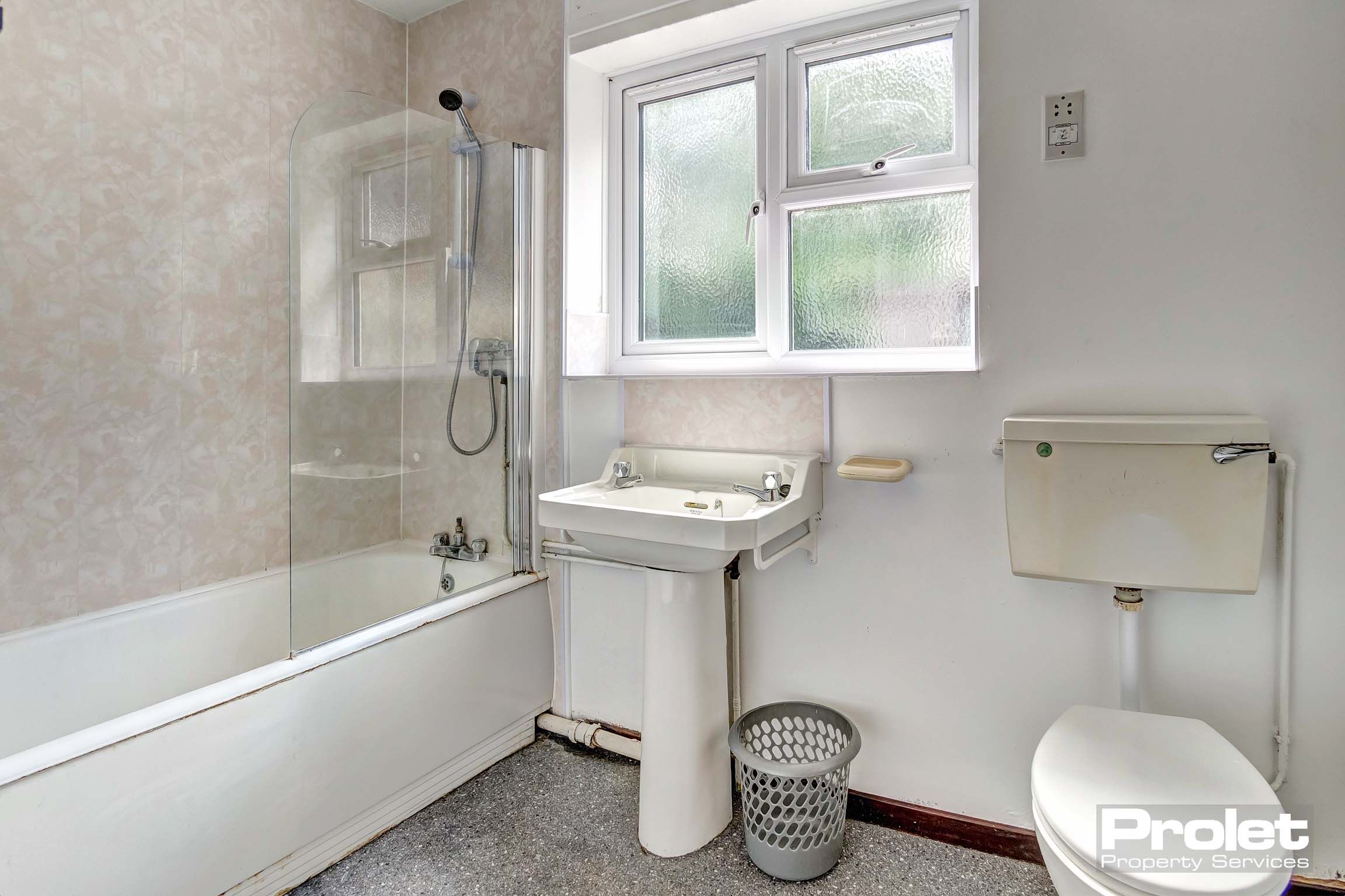 Bathroom with shower over bath, toilet, and sink