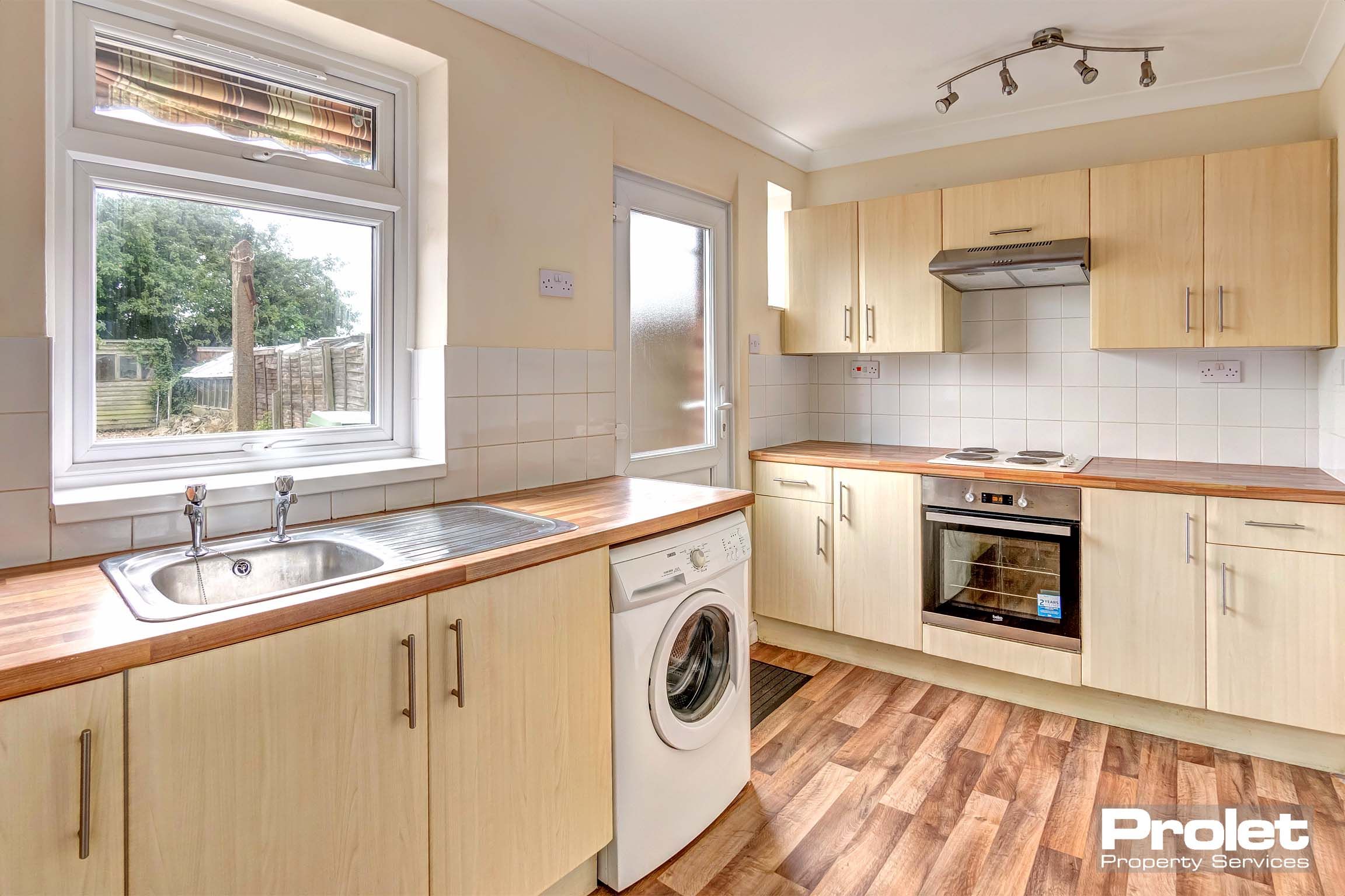 Wooden fitted kitchen with wooden effect lino flooring.