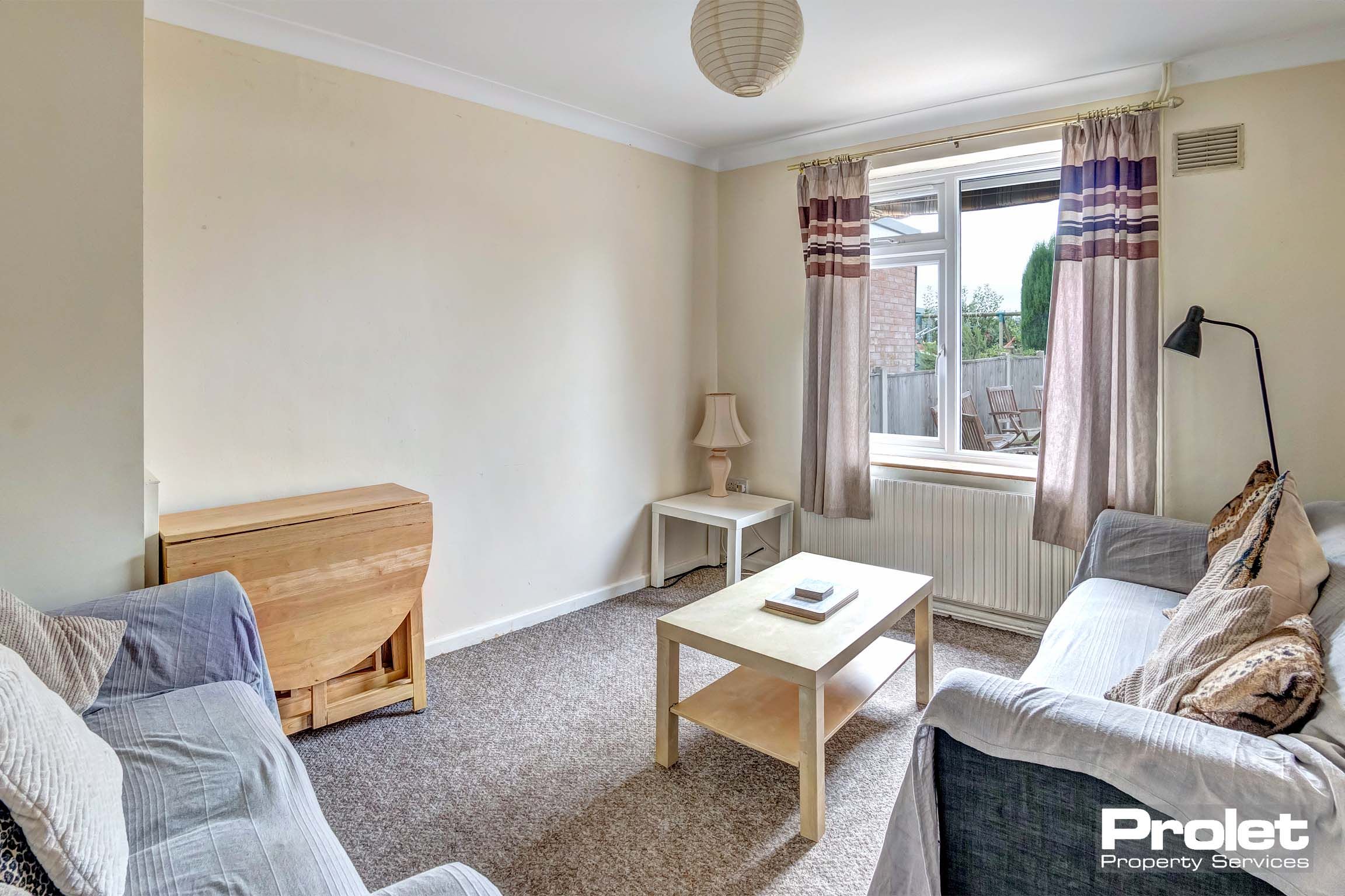 Lounge area with two sofas, a wooden centre table and a collapsible dining table.