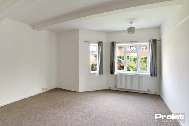 Large bedroom with beige carpet, and white walls