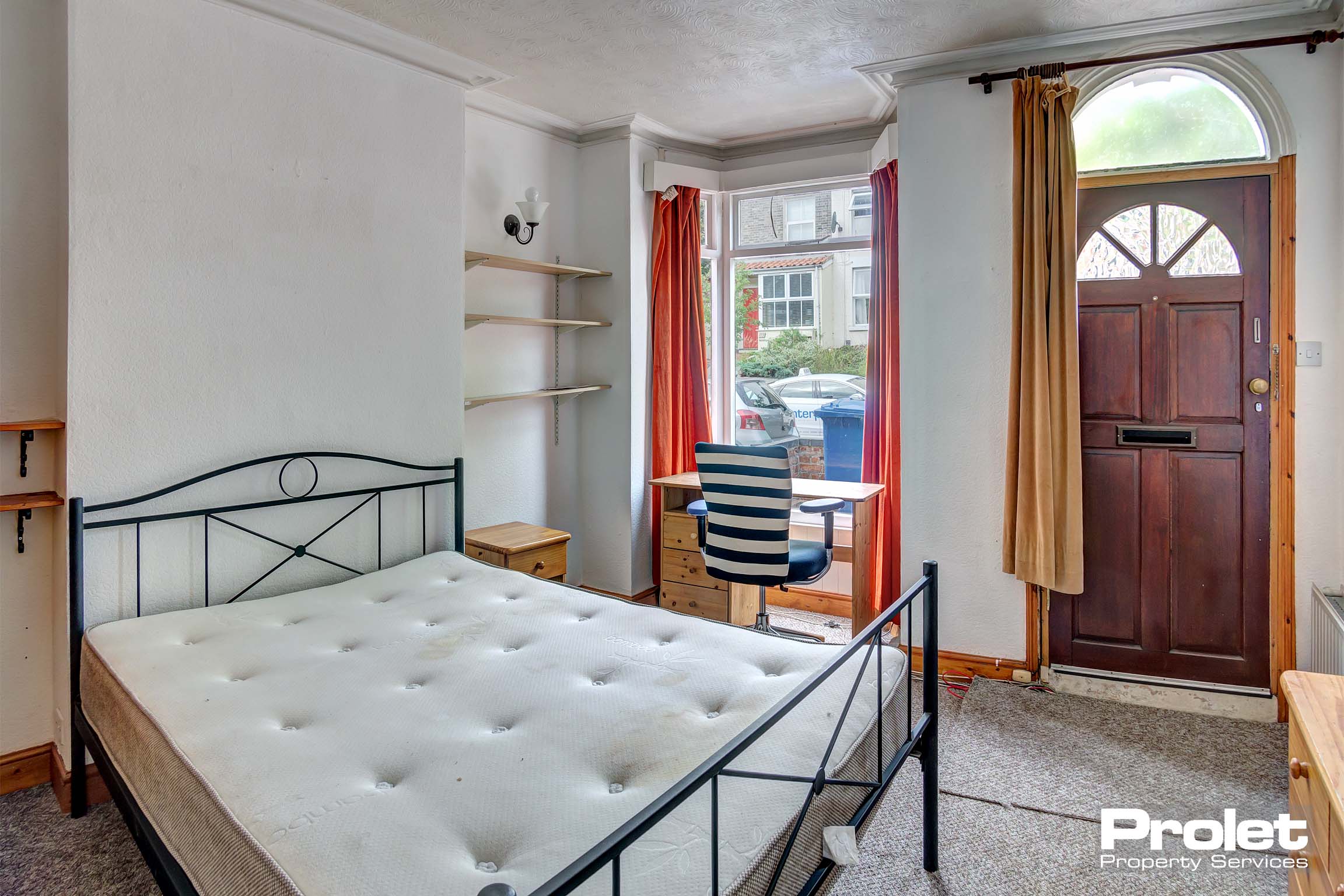 Downstairs bedroom with bay window, double bed, and desk