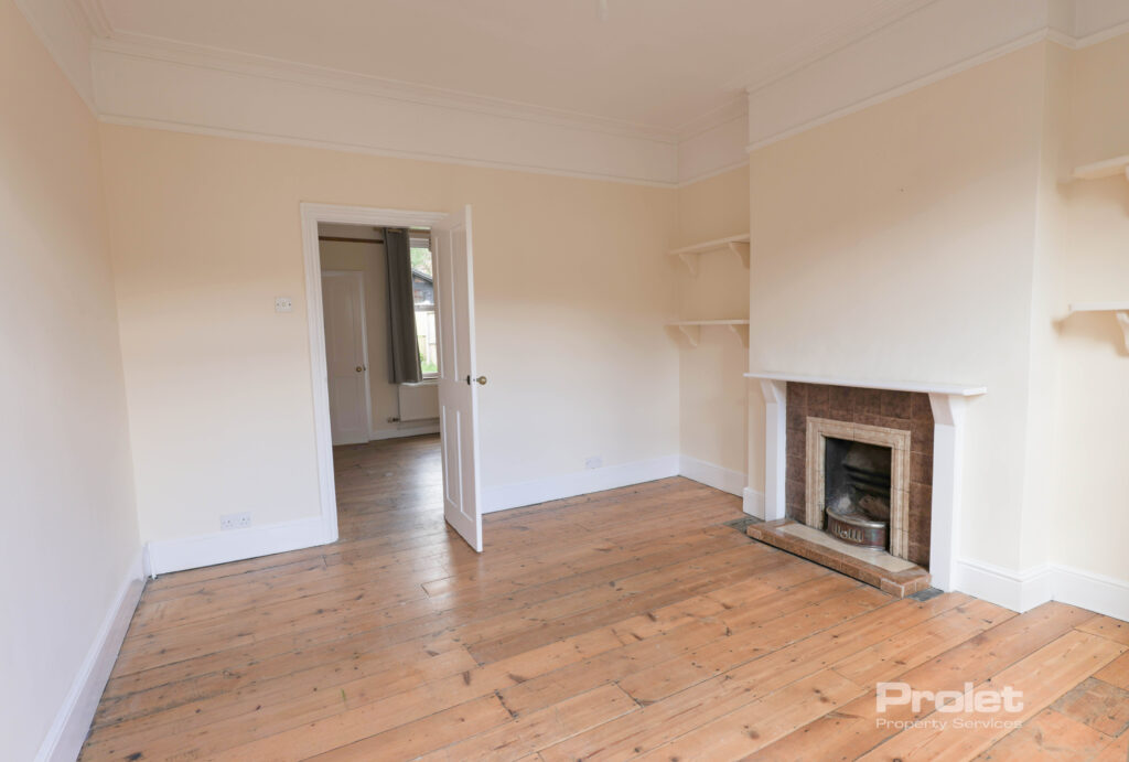 Living room with hardwood floors, and fireplace, leading to dining room