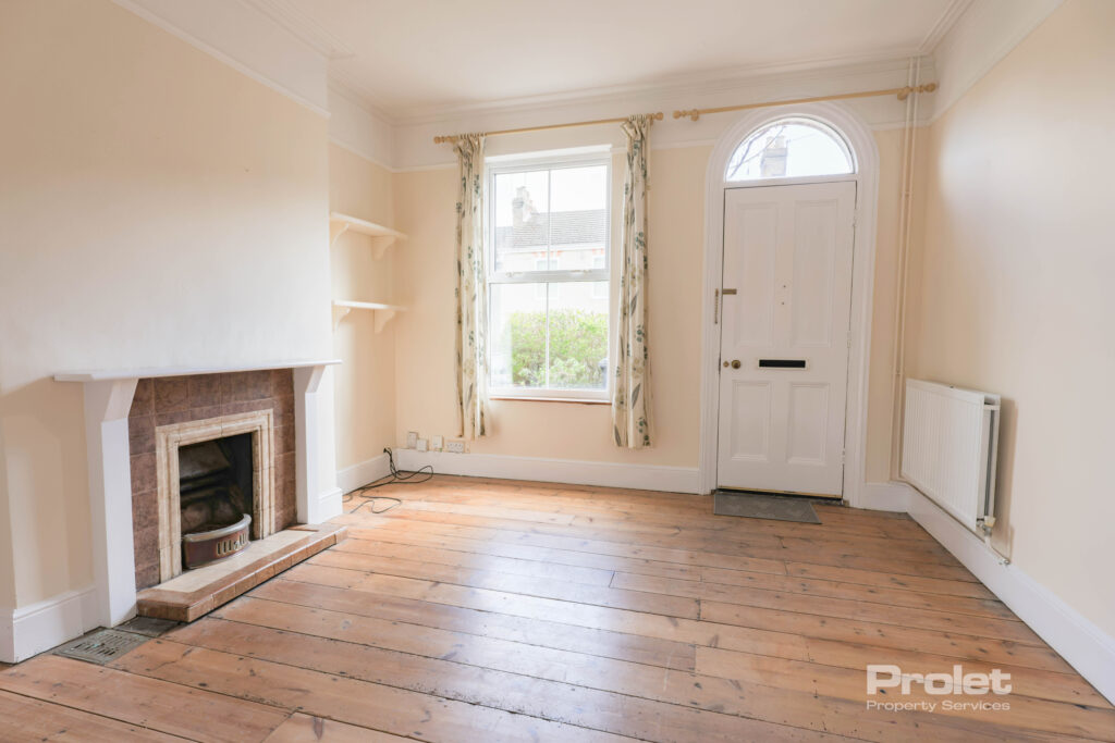 Living room with front door, fireplace, and hardwood floors