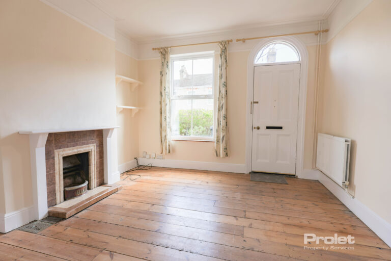 Living room with front door, fireplace, and hardwood floors