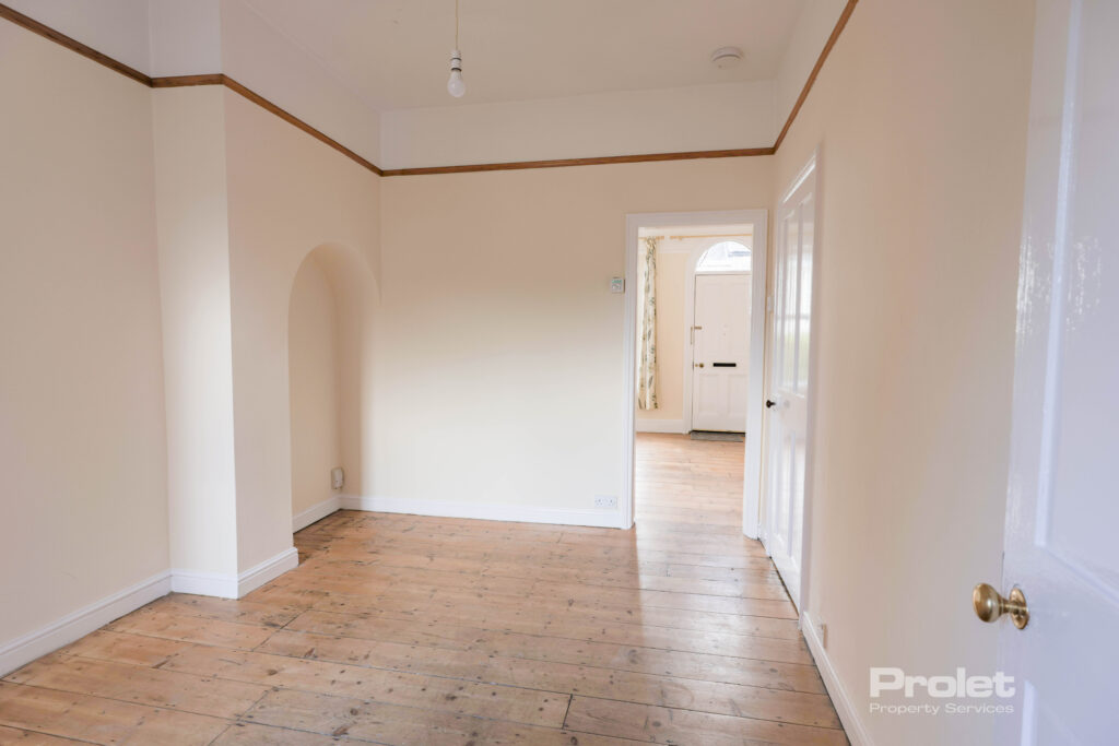 View of dining room, leading to living room. Hardwood floors, and cream walls throughout
