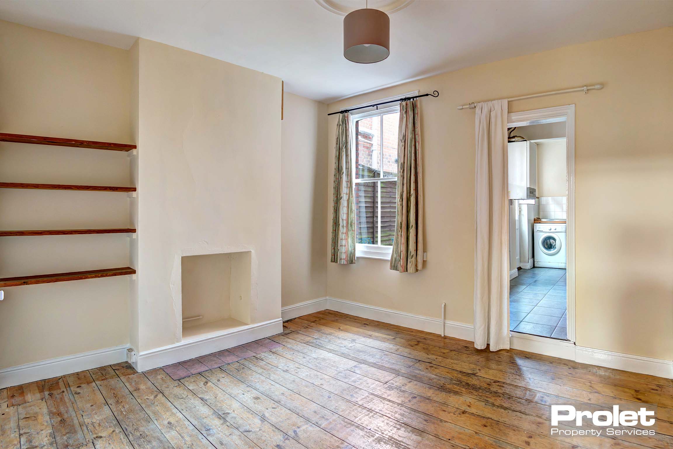 Dining room with hard wood floor and shelving. Leading to kitchen