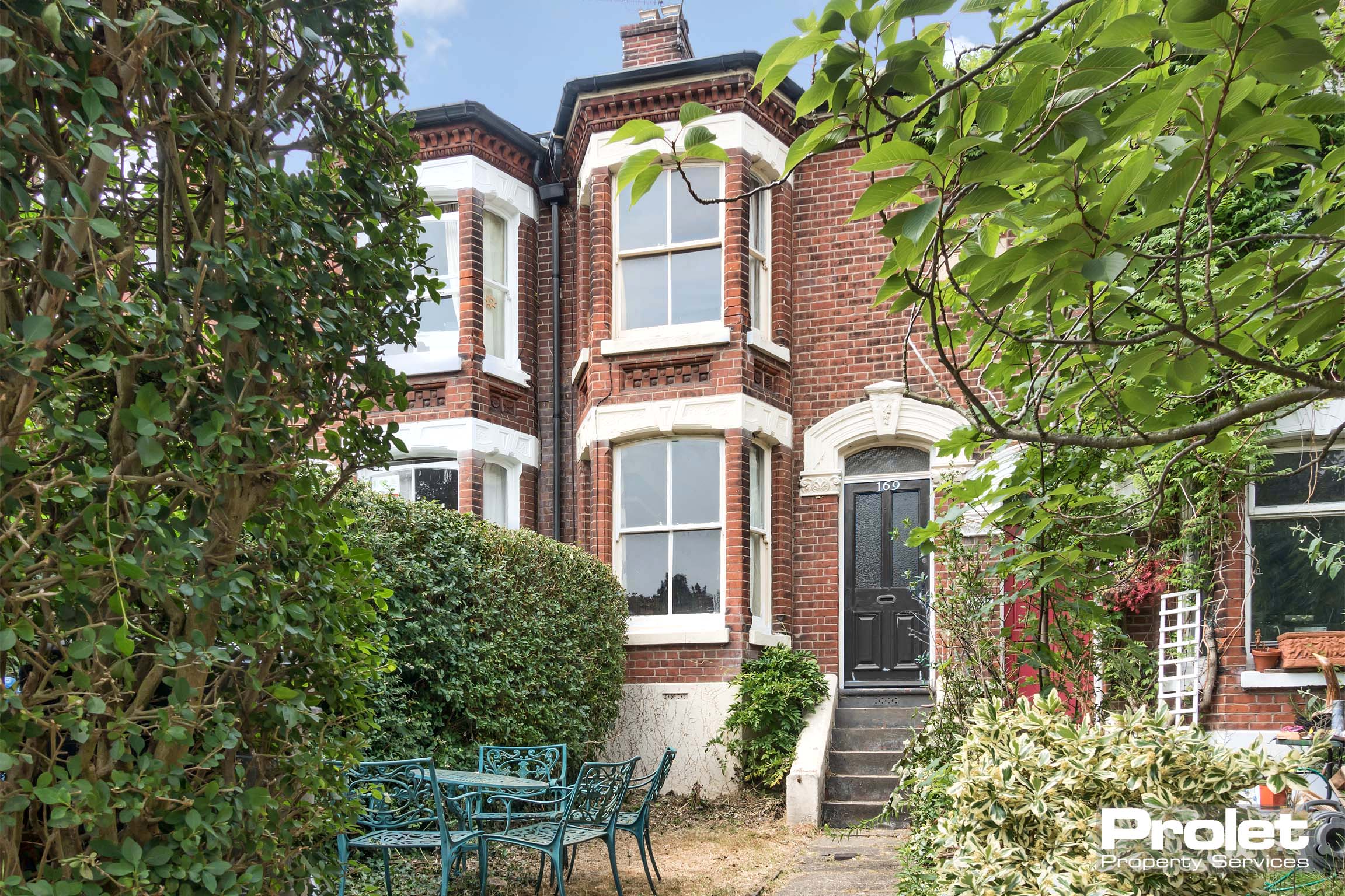 Large red brick terrace with steps leading to front door