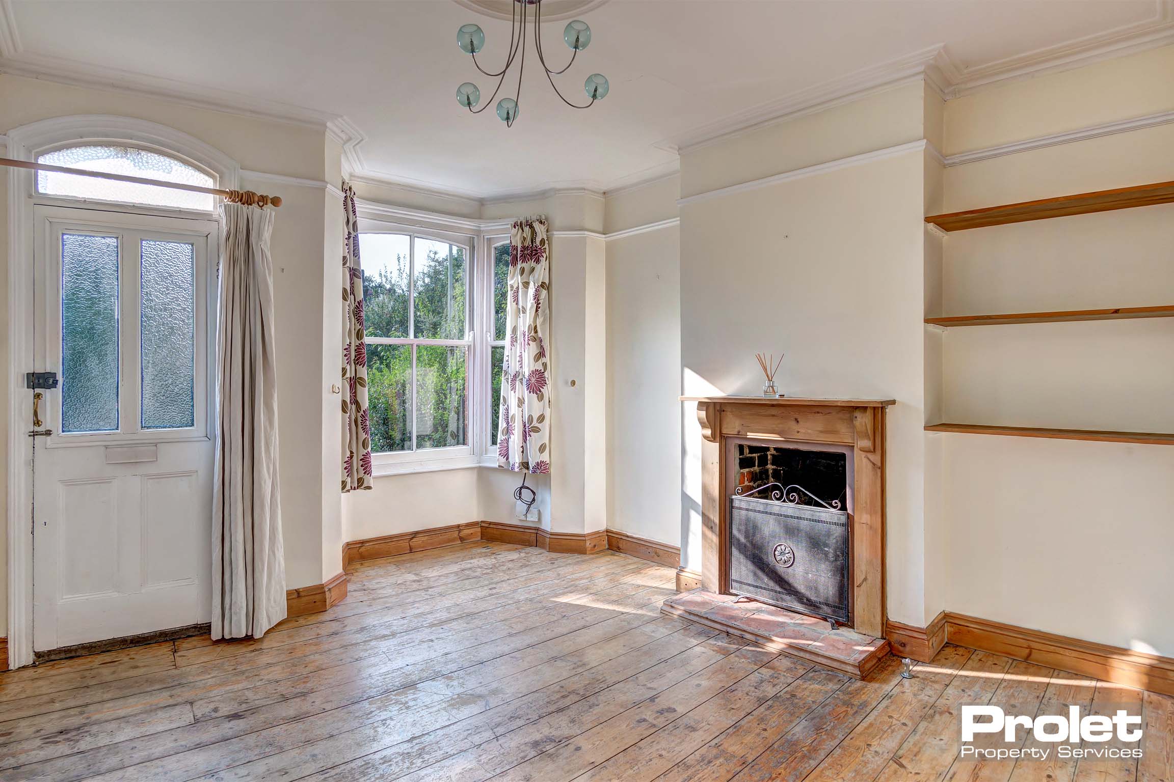 Living room with bay window, and fireplace.
