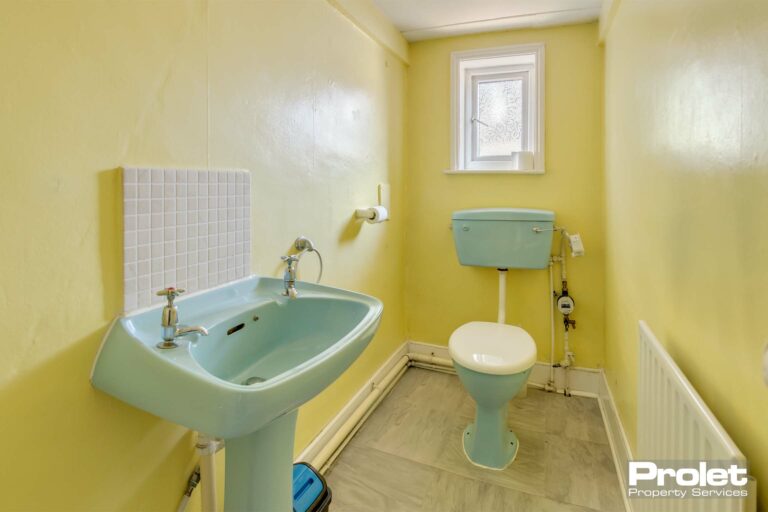 W.C with yellow walls and white toilet and sink