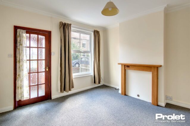 Magnolia walls, grey carpet. curtians to windows and pine feature fireplace surround