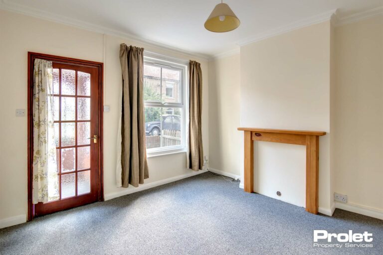Magnolia walls, grey carpet. curtians to windows and pine feature fireplace surround