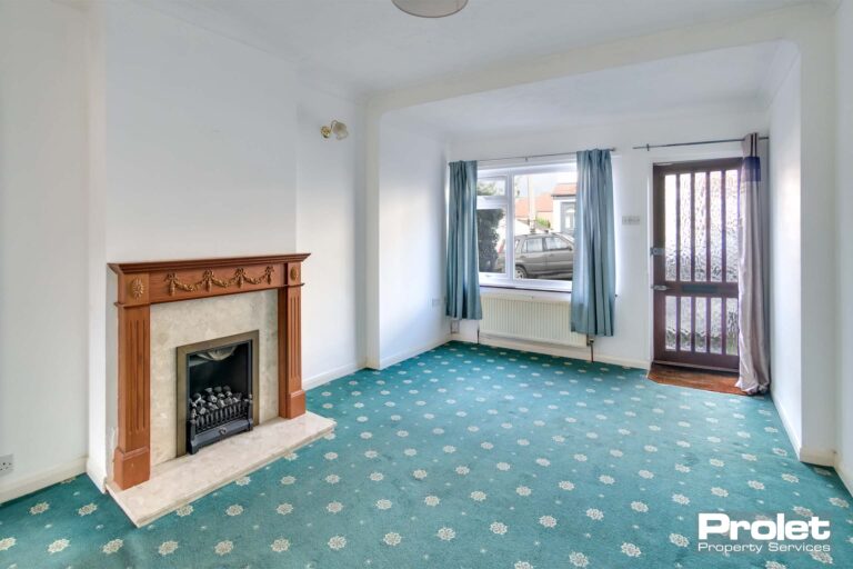 Large living room with fireplace and green carpet.