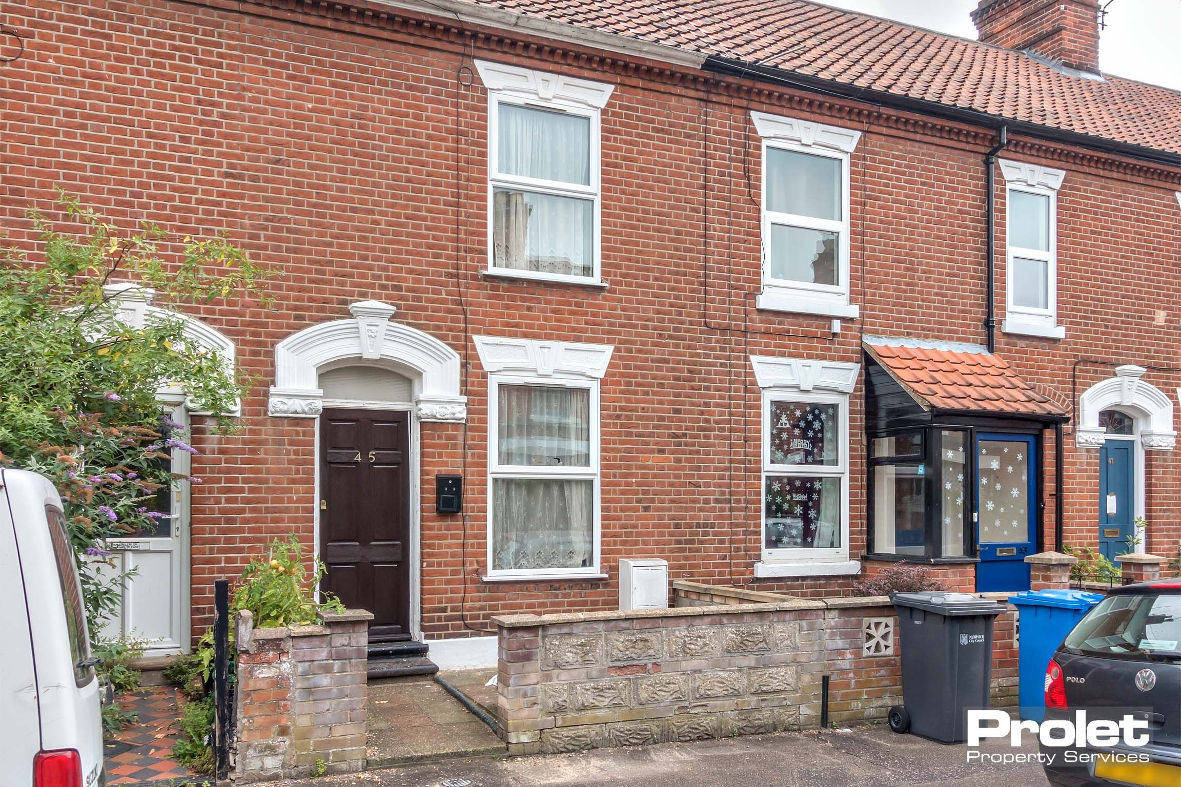 Red brick terraced house with brown front door