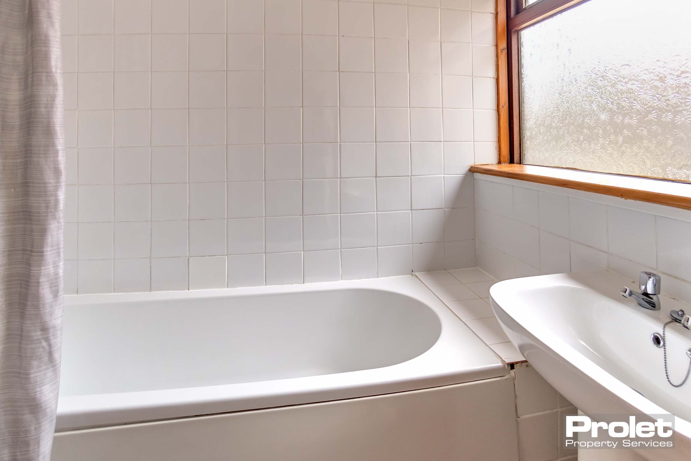 White bathroom suite and white wall tiles