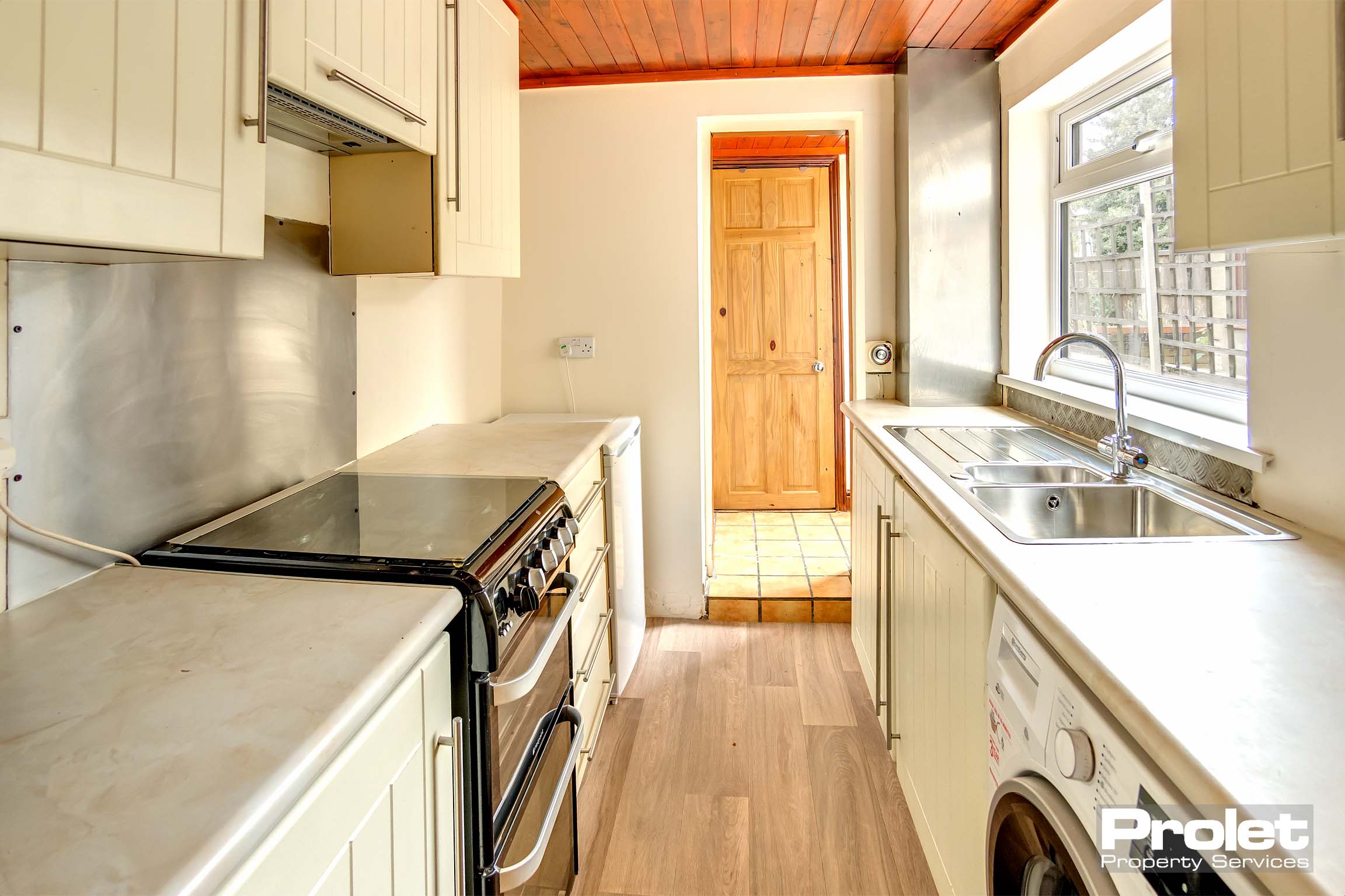 Laminate effect flooring, wooden ceiling and cream worktops and units