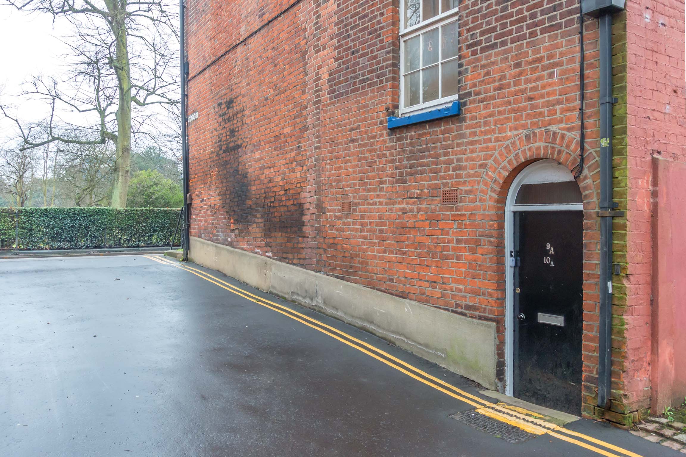 Access to property at side of building, black front door.