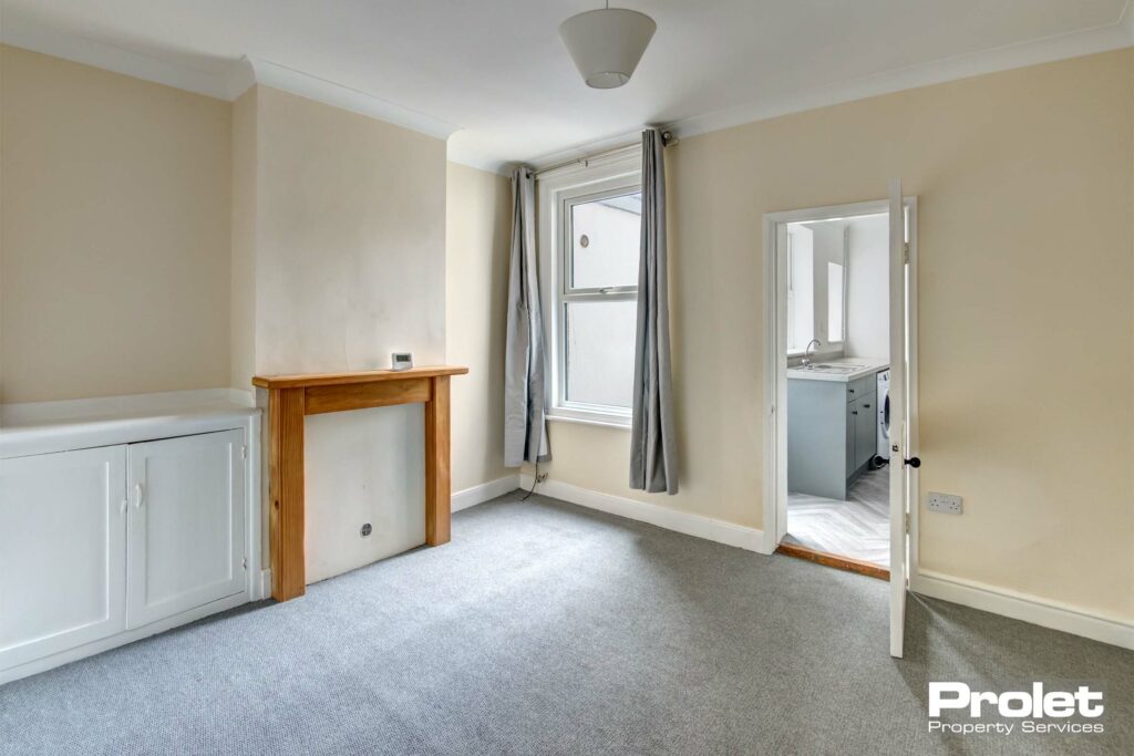 Spacious dining room with grey carpets, that leads to the kitchen