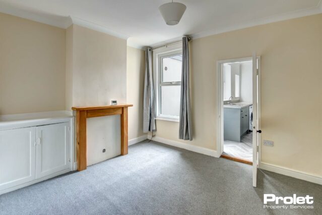 Spacious dining room with grey carpets, that leads to the kitchen