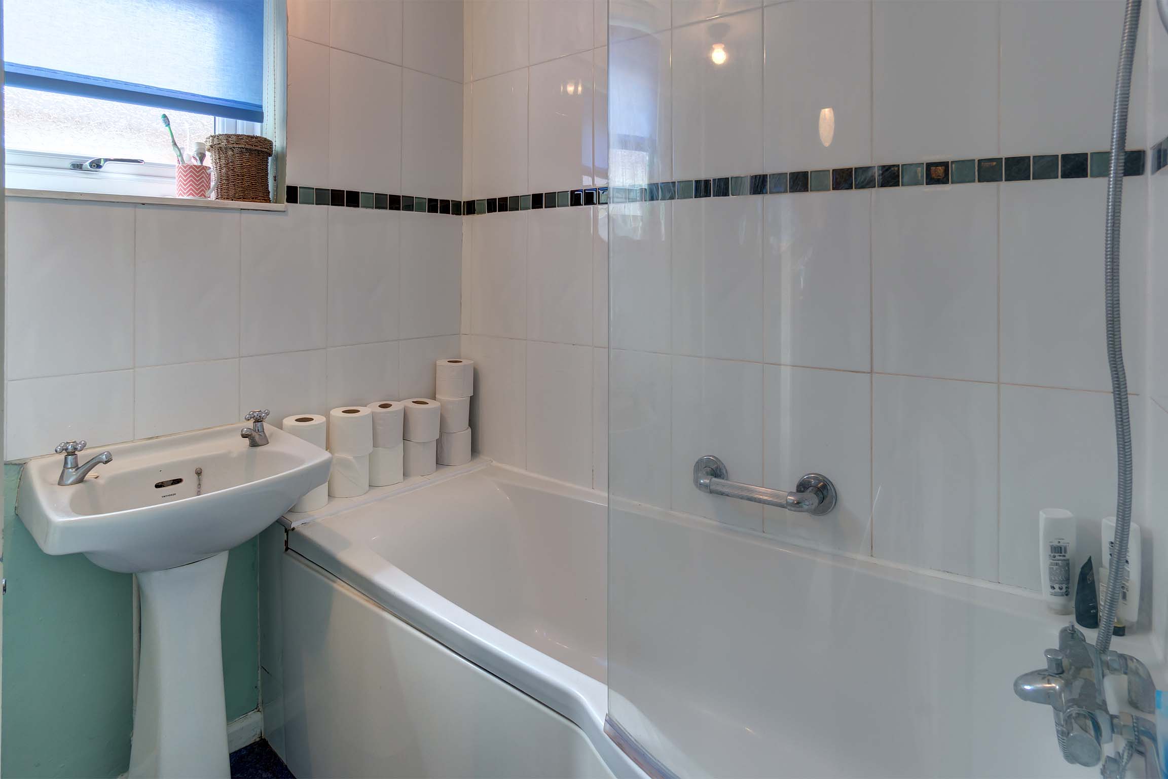 Downstairs bathroom with shower over bath and sink