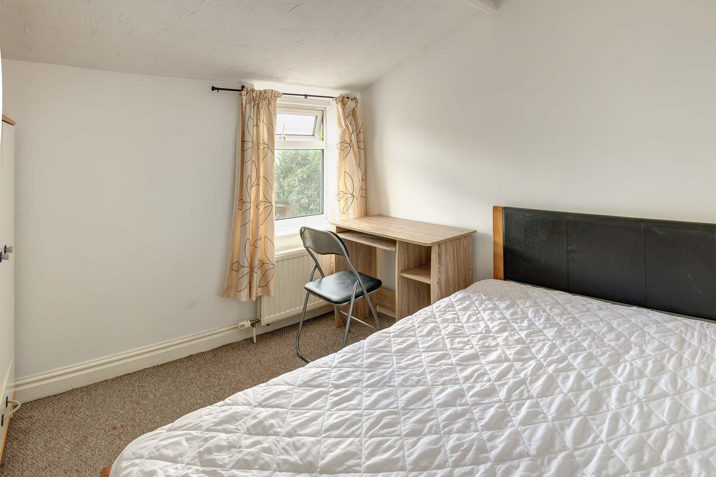 Bedroom with double bed and desk
