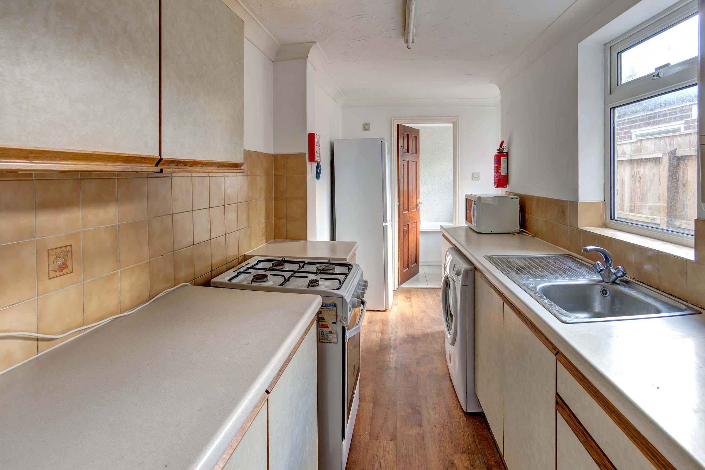 Long galley kitchen with white goods
