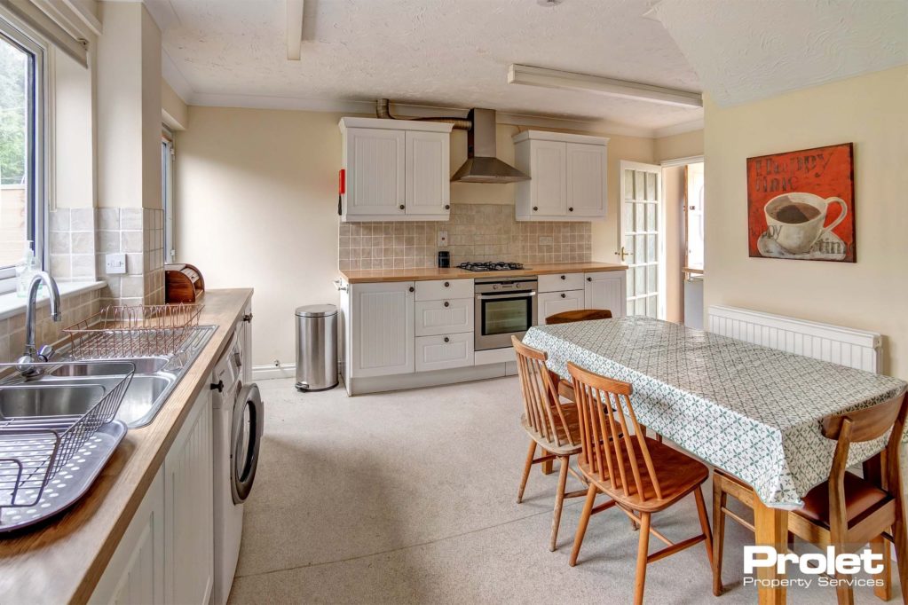 Kitchen space with dining space. A wooden dining table with matching wooden chairs.