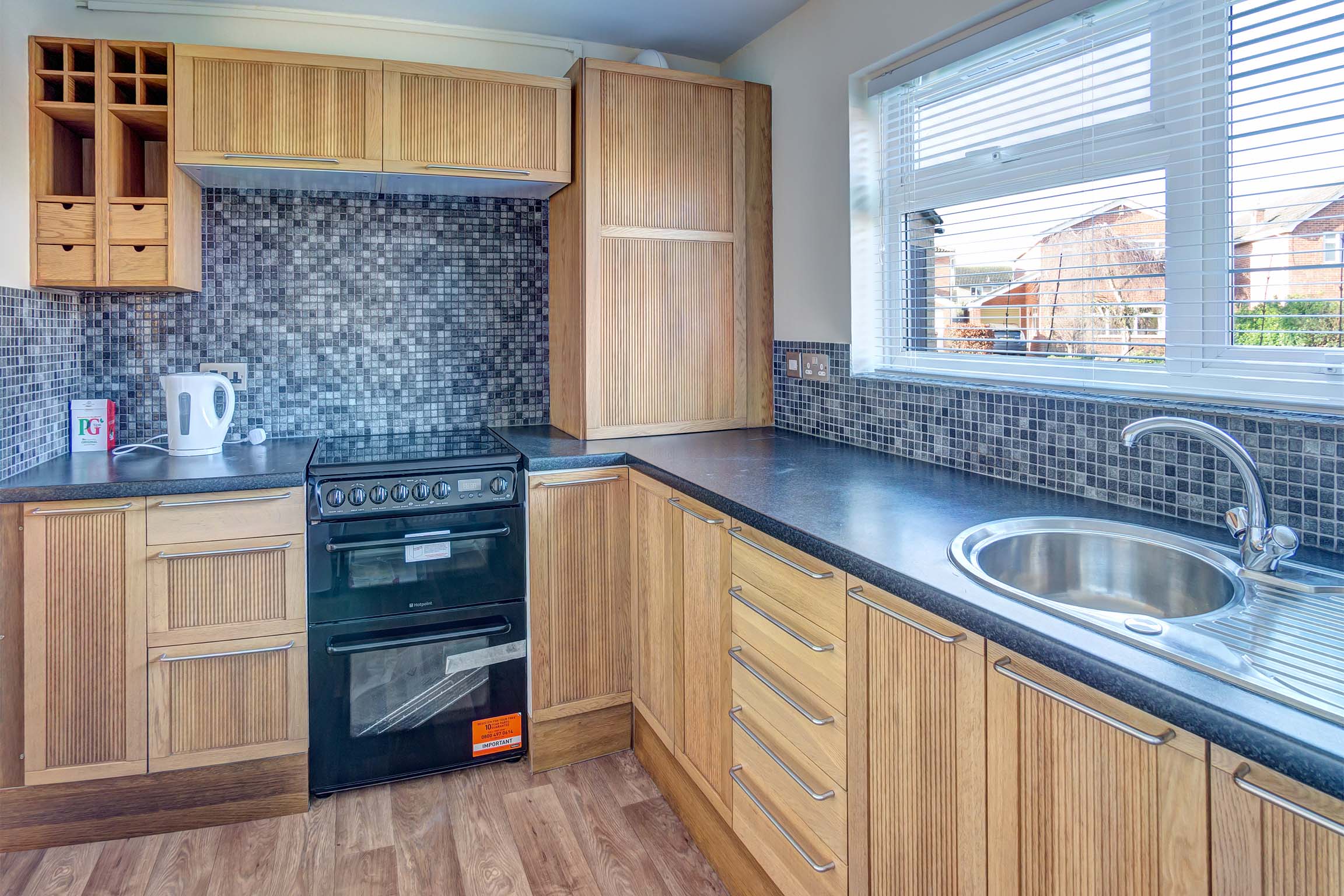 Built in wooden effect kitchen with black worktop.