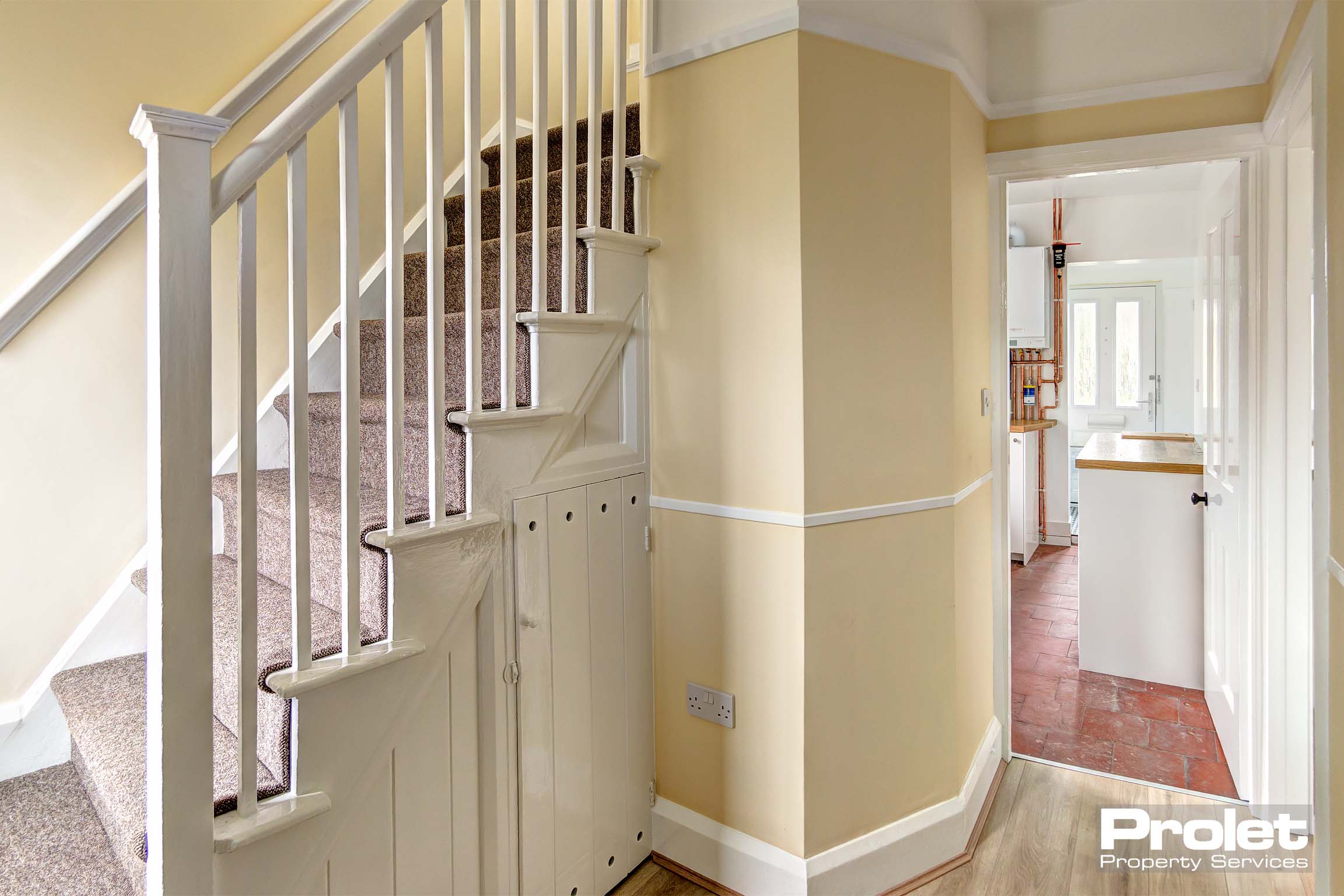 Hallway painted cream, leading to kitchen