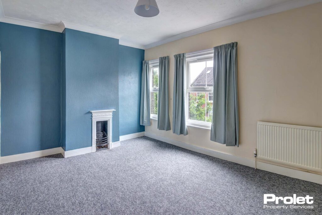 Grey carpet with blue and white painted walls and feature fireplace