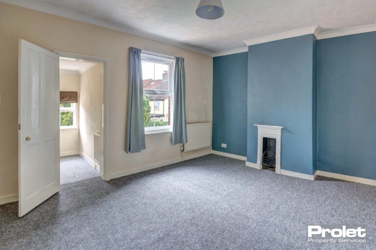 Grey carpet with blue and white painted walls and feature fireplace