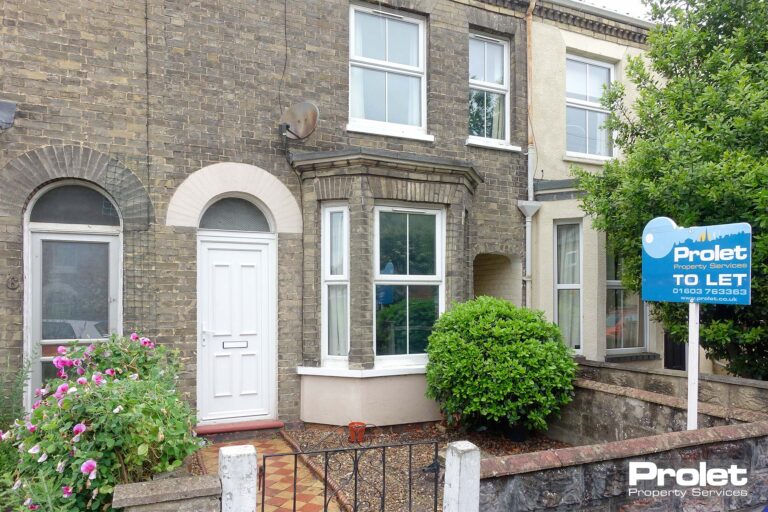 Brick house with small front garden, black gate and bay window
