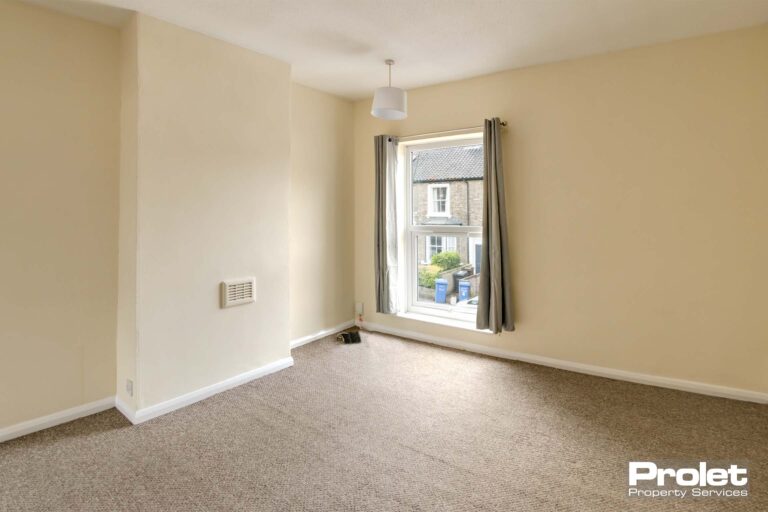 Upstairs front bedroom with cream walls and beige carpets