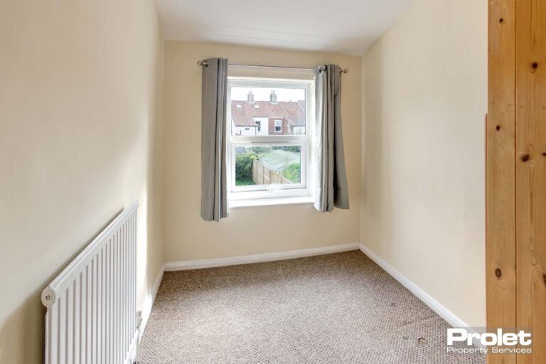Box room with beige carpet and cream walls