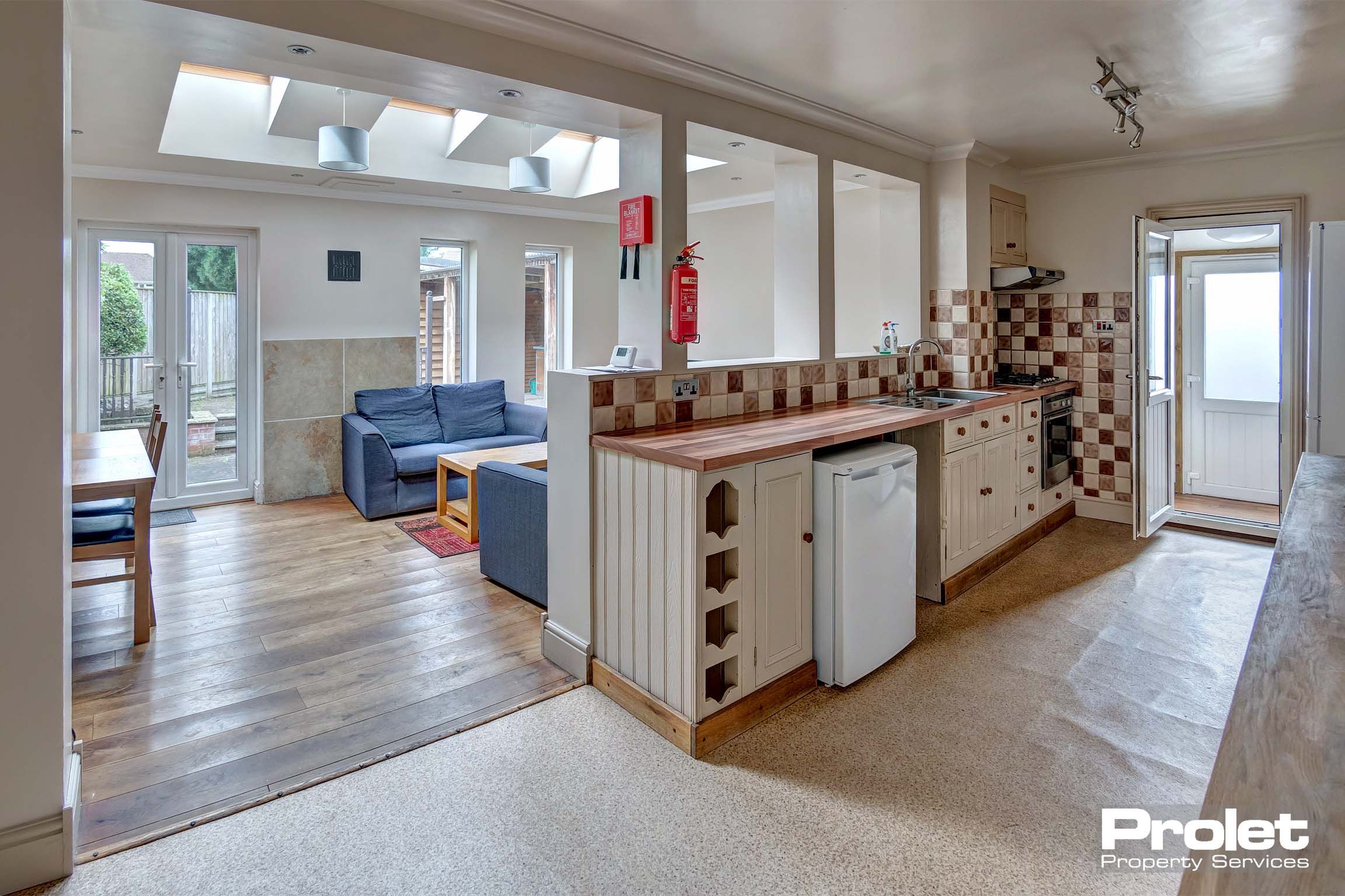 Open plan kitchen area with fitted kitchen cupboards and an under the counter fridge/freezer.