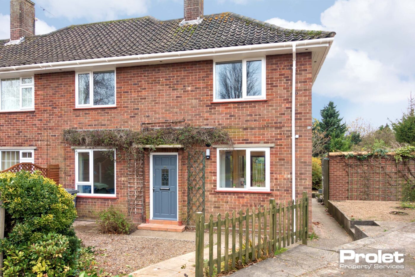 Semi detached brick house with a blue door