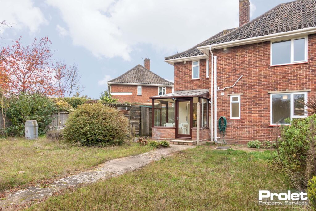 View of house from the rear, shed, and lawn.