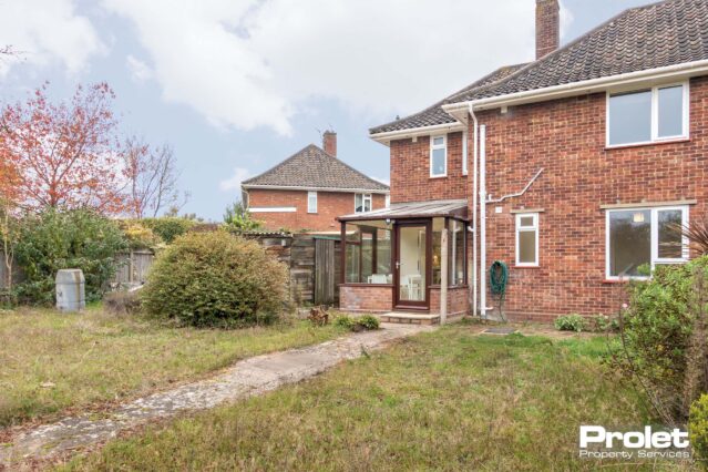 View of house from the rear, shed, and lawn.