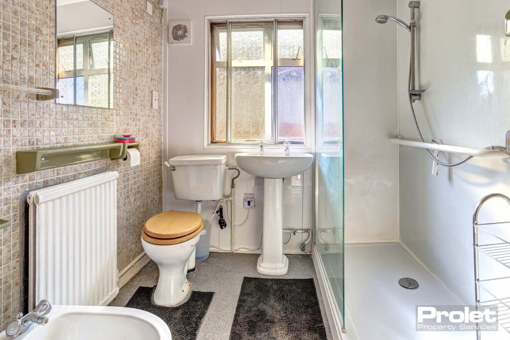Bathroom with walk in shower, toilet, sink, and bidet