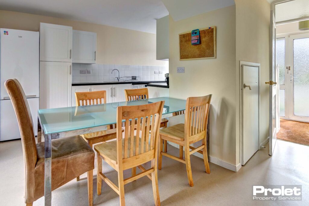 Dining area in kitchen, glass dining table and wooden chairs