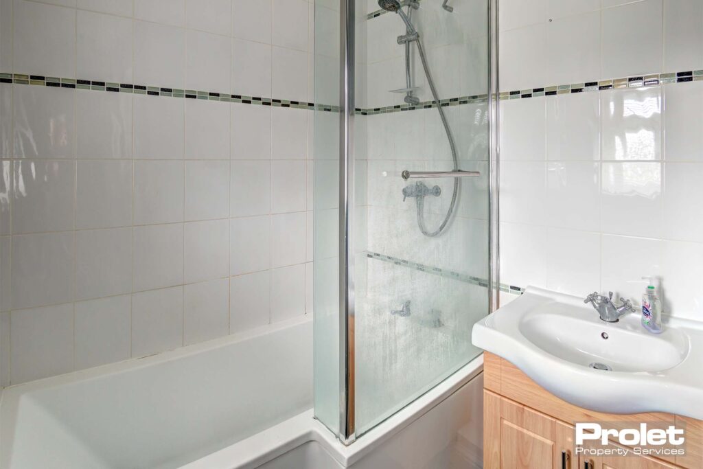 Bathroom with shower over bath and sink