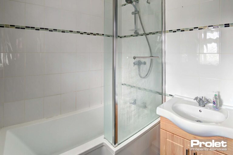Bathroom with shower over bath and sink